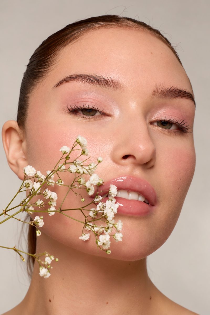 Fresh editorial makeup with peach cheeks and a glossy lip