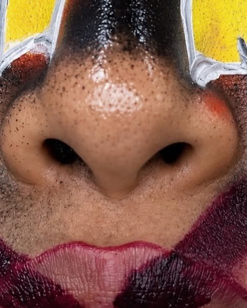 Creative editorial face art with bold yellow and deep red lip design
