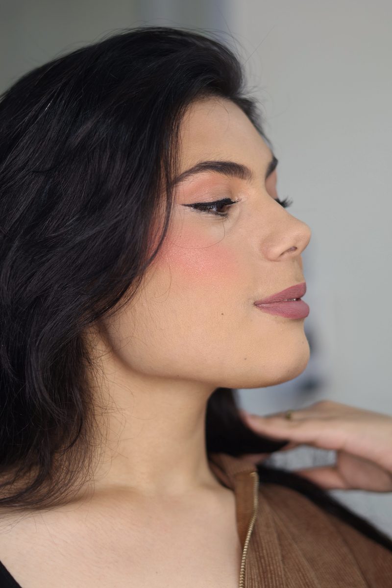 Side profile with a sculpted cheek, winged liner and mauve lip